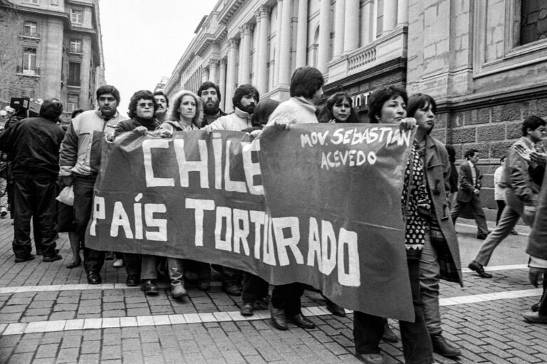 Manifestantes en la Plaza de Armas de Santiago en 1987, portando pancartas que denuncian la tortura.