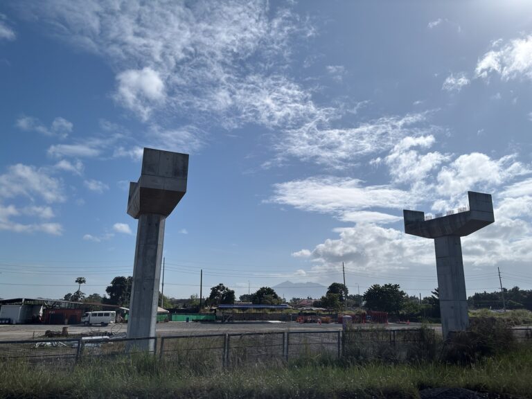 Estructuras de soporte de un viaducto en construcción bajo un cielo azul con nubes.