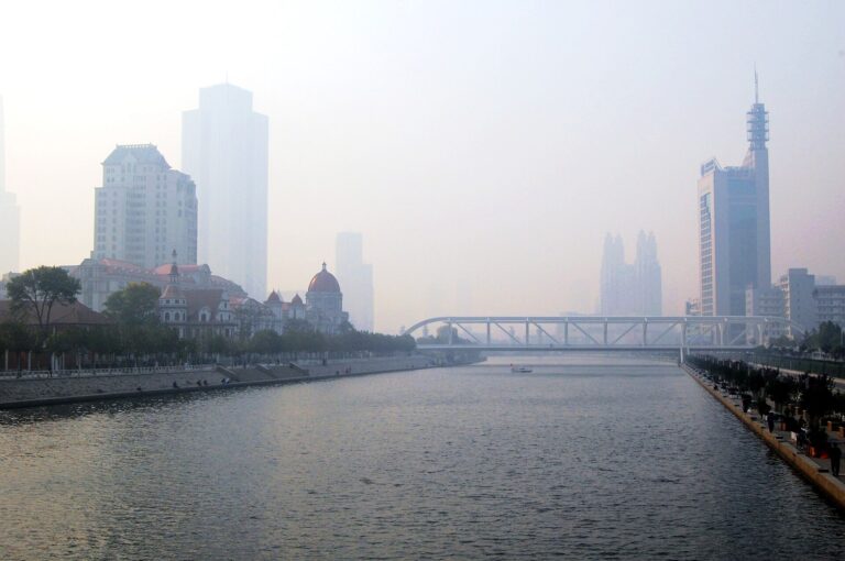 Vista panorámica de un río con edificios en la distancia bajo una neblina densa.