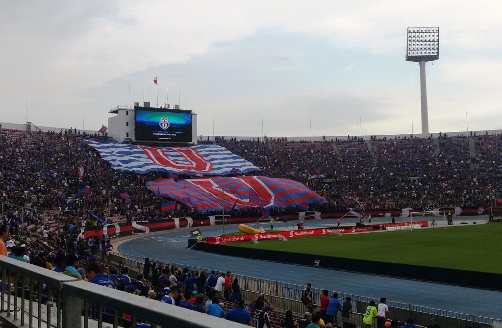 Barras de aficionados en el Estadio Nacional durante un evento de fútbol.