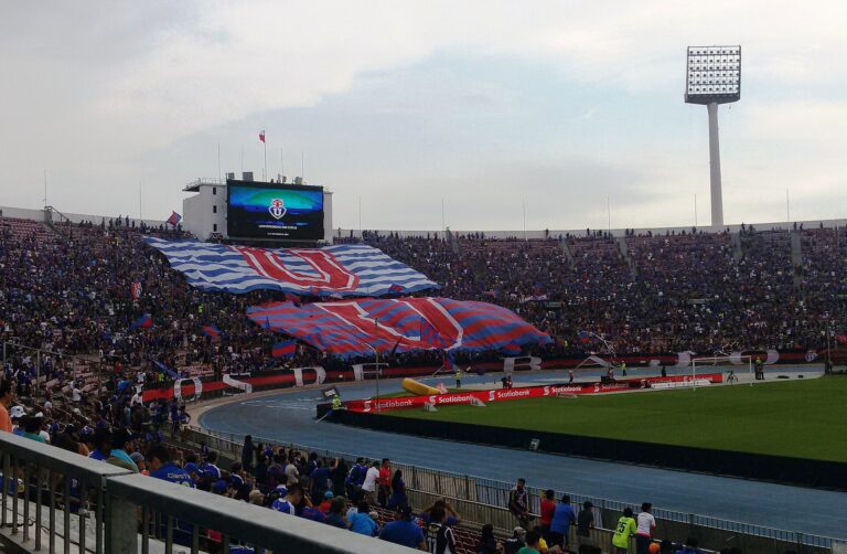 Barras de aficionados en el Estadio Nacional durante un evento de fútbol.