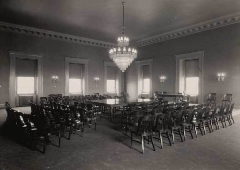 Interior de una cámara de senado en el Capitolio de EE. UU., mostrando mesas y sillas dispuestas para sesiones legislativas.