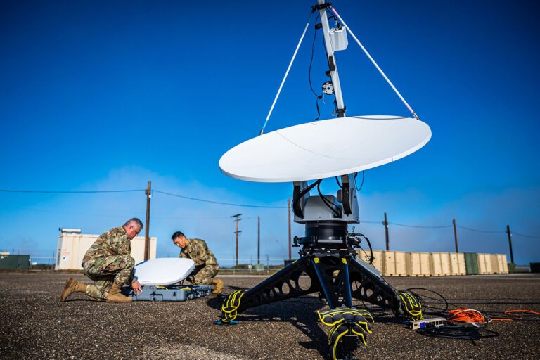 Personal militar instalando una antena de guerra electrónica en un campo de pruebas.