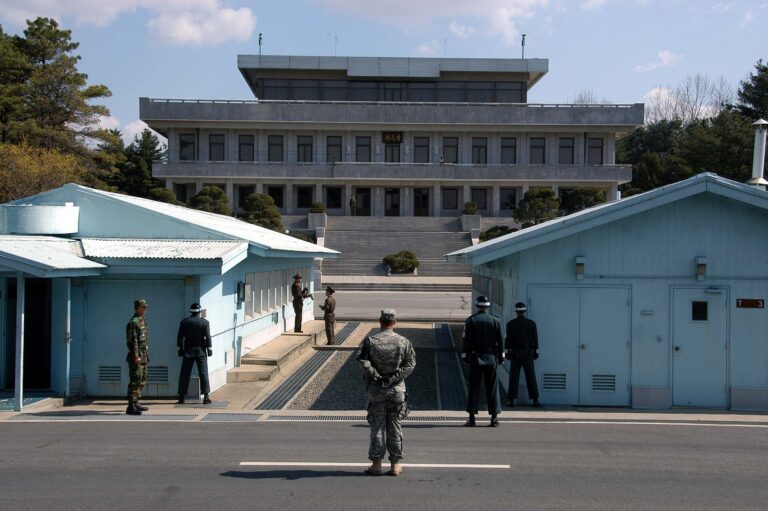 Vista desde Corea del Sur hacia Corea del Norte en la Zona de Seguridad Conjunta de Panmunjom. Se ven militares de ambos países y un soldado estadounidense.