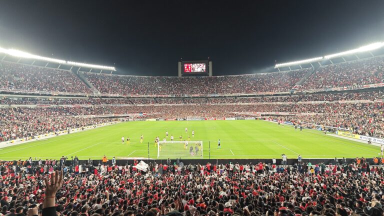 Vista panorámica del estadio lleno con el campo de juego listo para un partido de fútbol.
