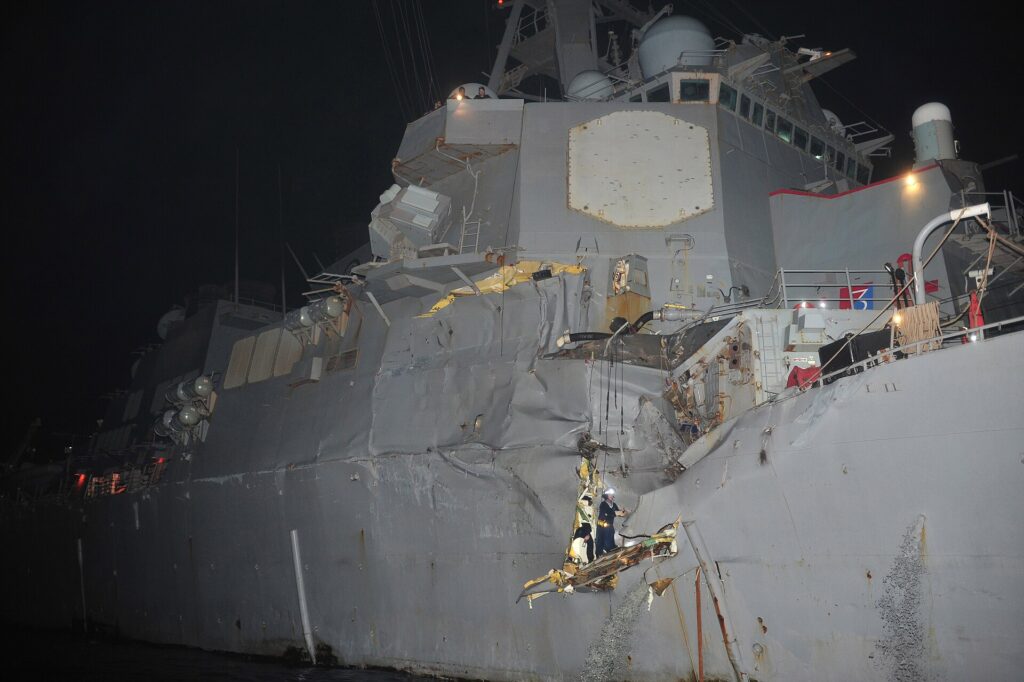 Vista nocturna de un destructor de guerra dañado en el Estrecho de Ormuz.