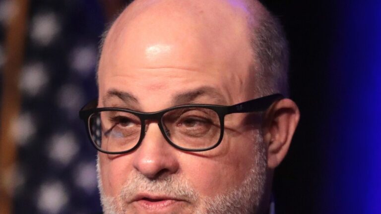 Mark Levin hablando en un evento, con gafas y traje oscuro.
