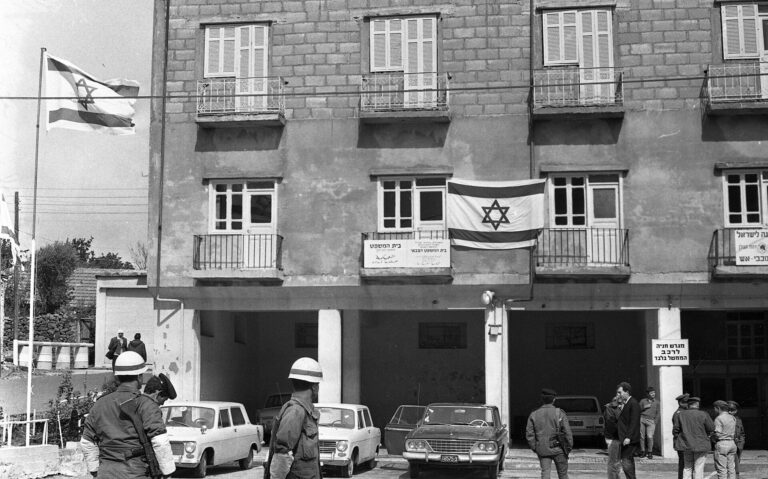 Fachada de un edificio en Quneitra con banderas israelíes y árabe.