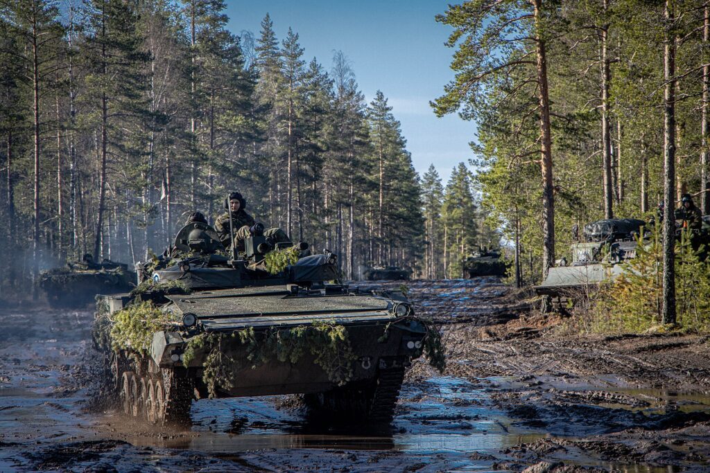 Soldados en vehículos militares en un ejercicio de entrenamiento en un bosque.