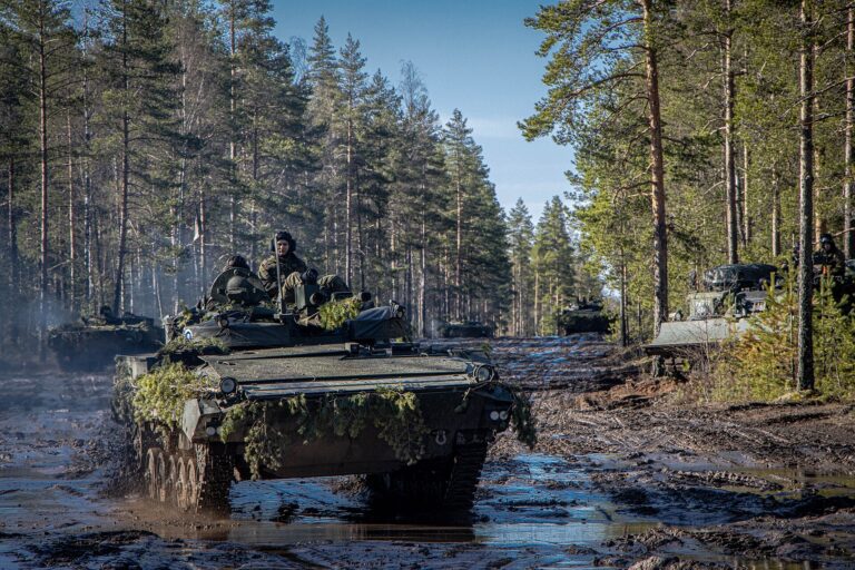 Soldados en vehículos militares en un ejercicio de entrenamiento en un bosque.