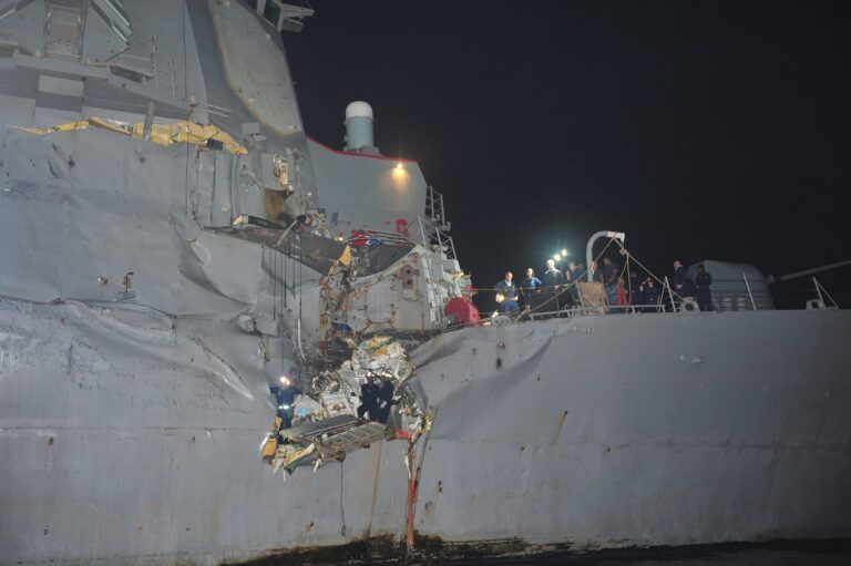 Vista nocturna del destructor USS Porter dañado en el muelle o en el agua.