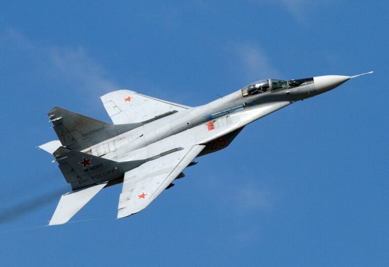 Un caza MiG-29S ruso vuela contra un cielo azul despejado.