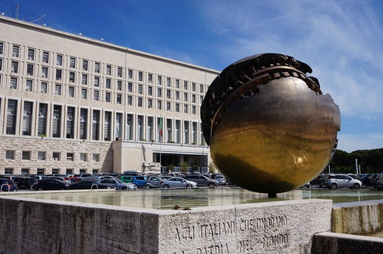 Fachada del Ministerio de Asuntos Exteriores de Roma, Italia, con una gran esfera de bronce en primer plano.