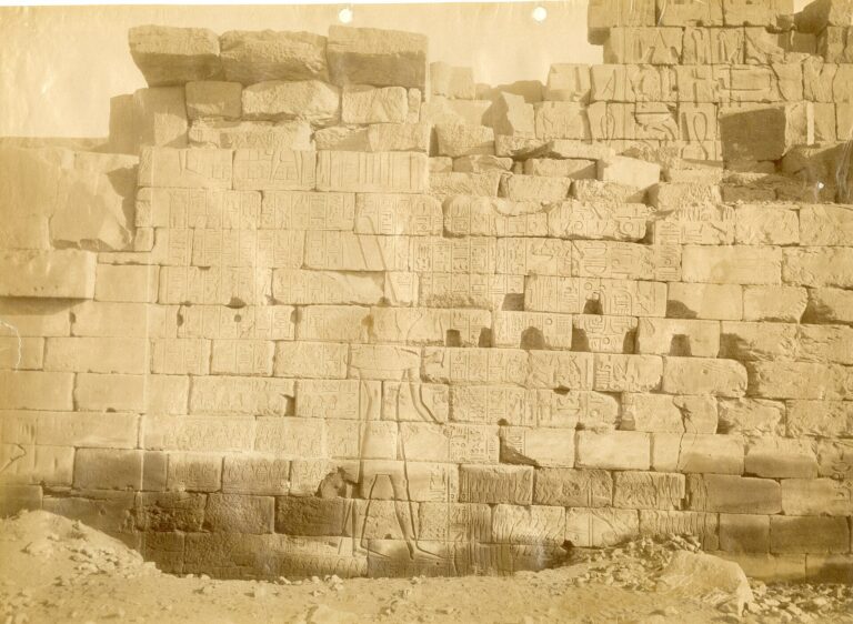Muro antiguo de un complejo de templos en Karnak, Egipto, mostrando inscripciones y arquitectura histórica.