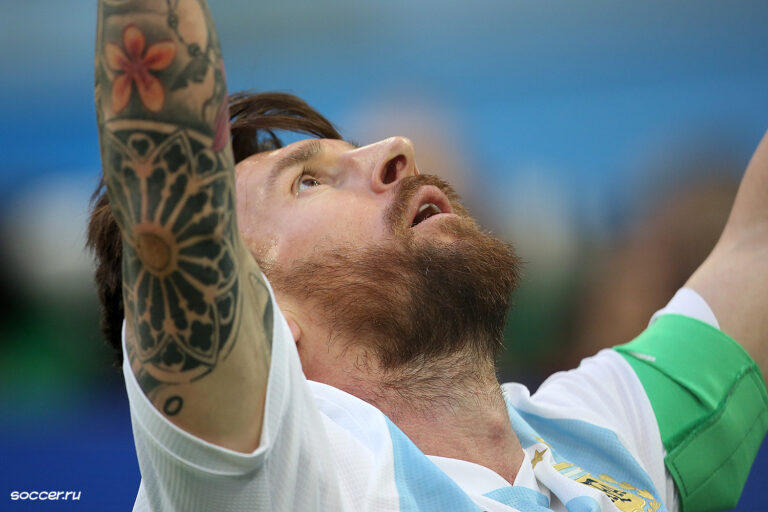 Lionel Messi celebra un gol con los brazos levantados en el campo de juego.