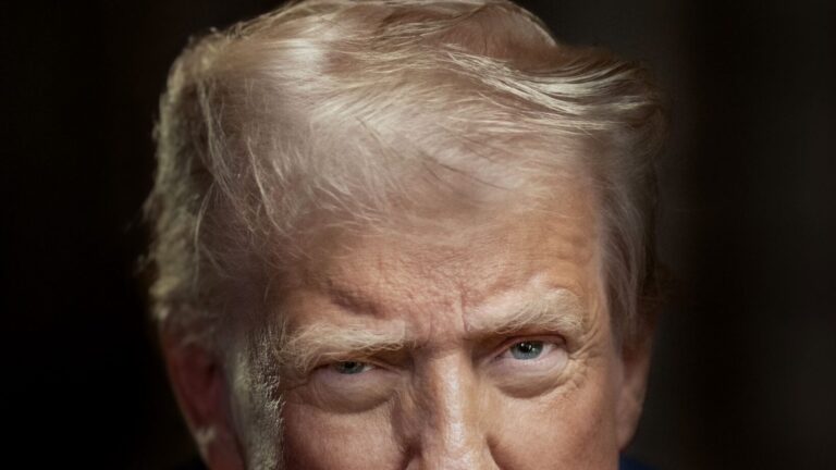 Retrato oficial de Donald J. Trump, en un traje azul oscuro, mirando directamente a la cámara.
