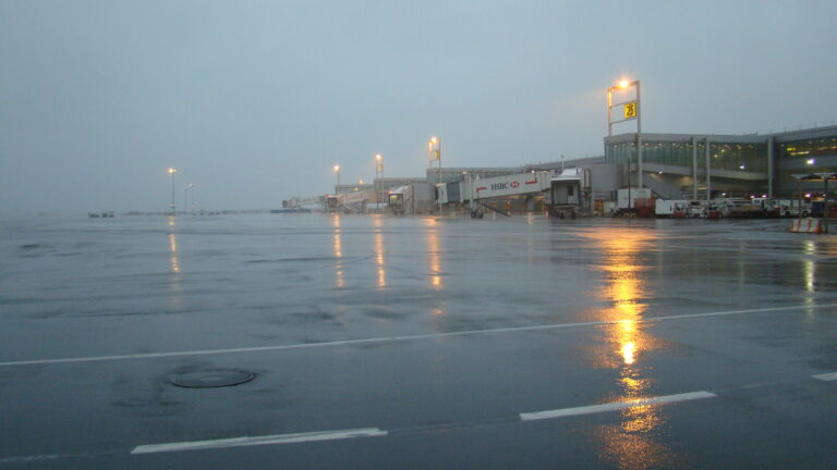 Tarmac vacío de un aeropuerto bajo condiciones climáticas adversas, mostrando la infraestructura aeroportuaria.