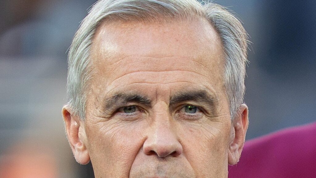 Retrato de Mark Carney, un hombre de mediana edad con traje y corbata, mirando directamente a la cámara.