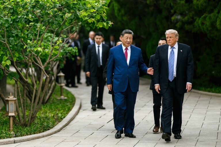 Donald Trump y Xi Jinping caminando juntos en un sendero arbolado.