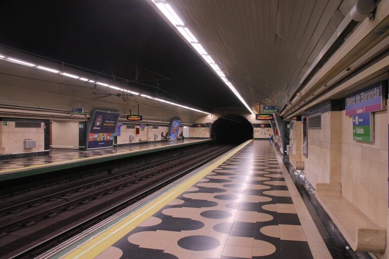 Vista del andén de la estación de Sainz de Baranda, Madrid, con vías de tren y señalización.