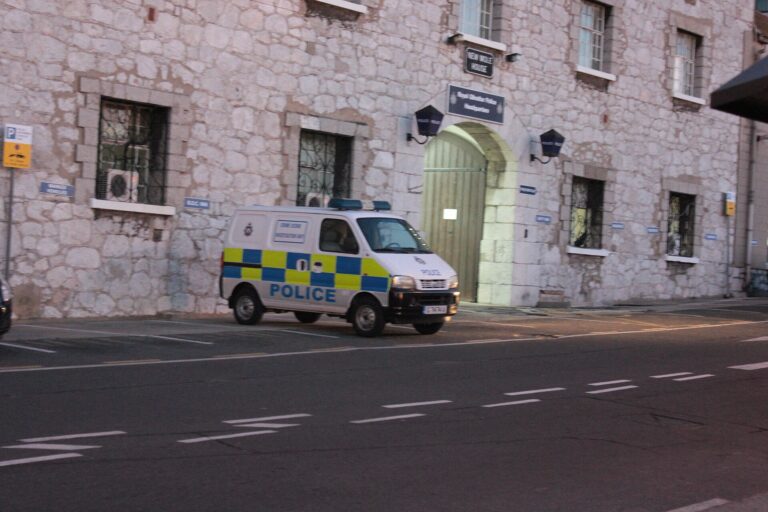 Escena de investigación policial en una calle urbana, con una patrulla visible.