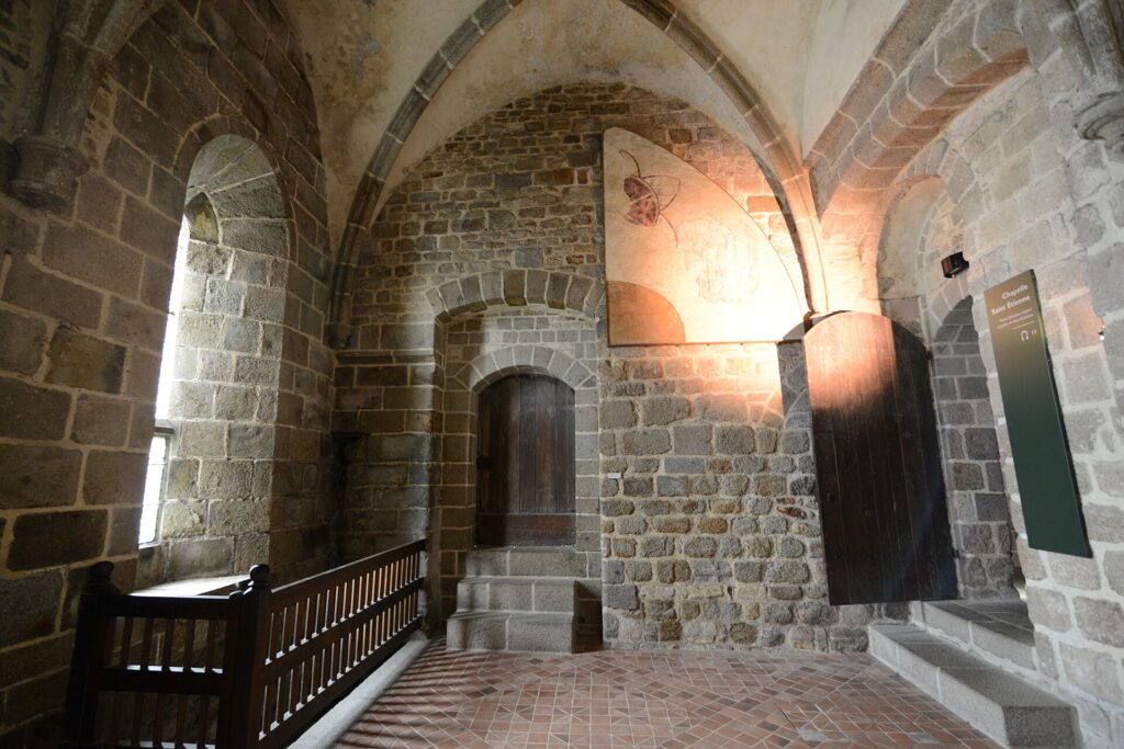Interior de una abadía benedictina, mostrando arcos y arquitectura histórica.