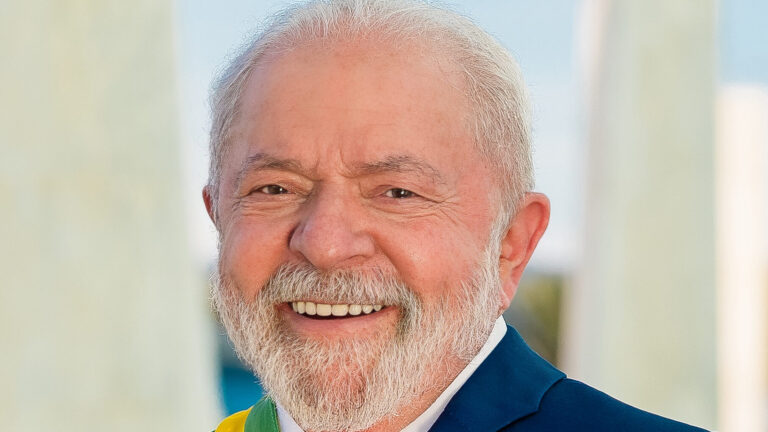 Retrato oficial de Luiz Inácio Lula da Silva, con barba y traje azul, sonriendo.
