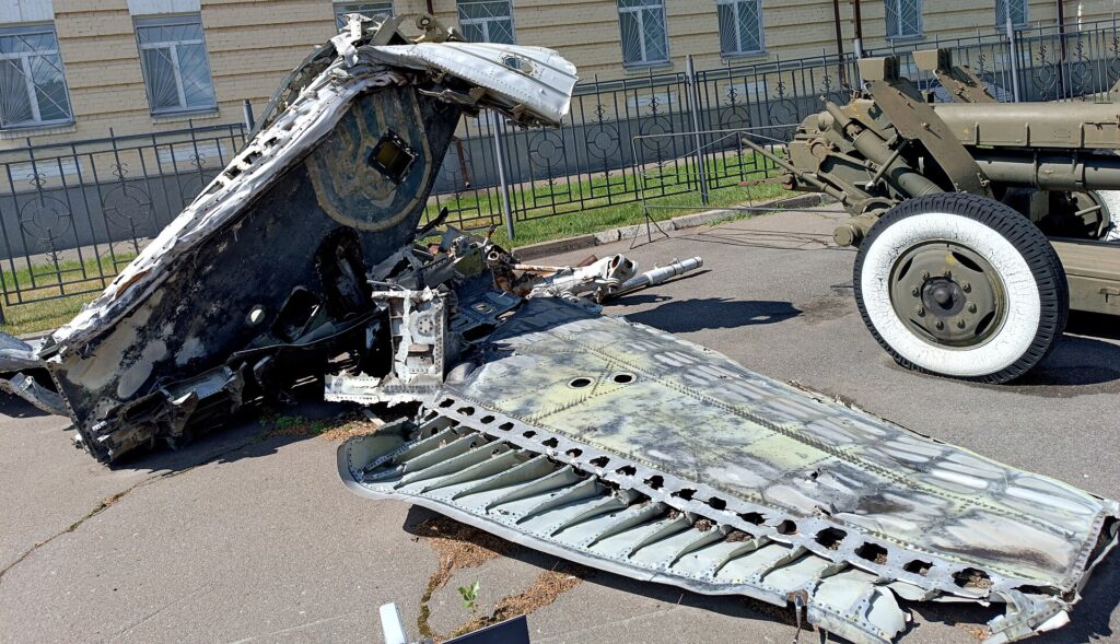 Restos de un vehículo militar, posiblemente un avión o tanque, en un área exterior.