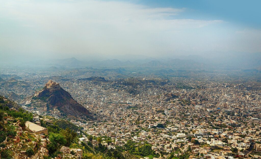 Vista panorámica de la ciudad de Taiz, Yemen, con colinas y montañas al fondo.