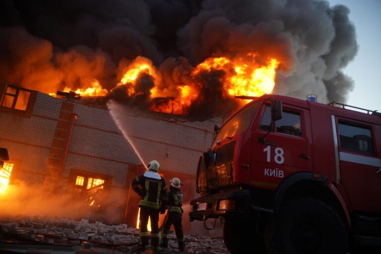 Edificio en llamas en Kyiv después de bombardeos rusos, con personal de emergencia en la escena.